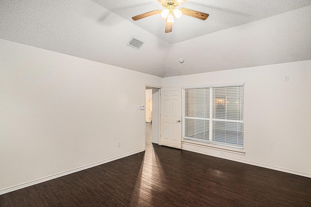 unfurnished room with lofted ceiling, ceiling fan, wood finished floors, visible vents, and baseboards