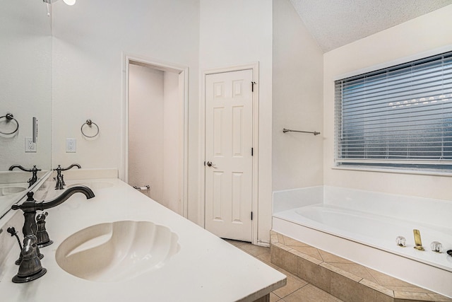 full bath with a sink, a garden tub, tile patterned flooring, and a textured ceiling