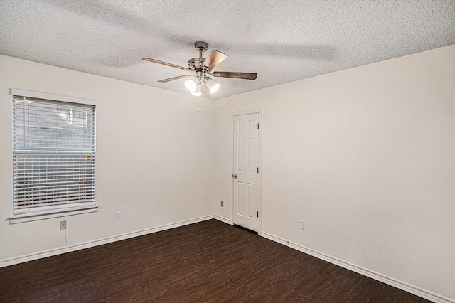 empty room featuring dark wood-type flooring, a textured ceiling, baseboards, and a ceiling fan