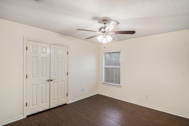 unfurnished bedroom with baseboards, dark wood finished floors, a ceiling fan, a textured ceiling, and a closet