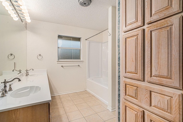 full bath featuring a textured ceiling, a sink, and tile patterned floors