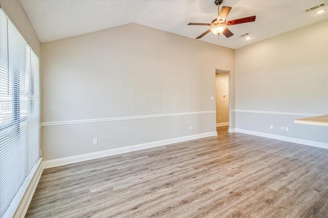 unfurnished room with lofted ceiling, visible vents, ceiling fan, and wood finished floors