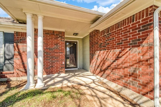 entrance to property featuring brick siding