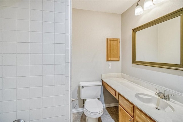 bathroom with tile patterned flooring, baseboards, vanity, and toilet