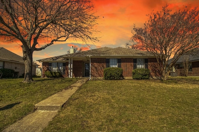 single story home with a front yard and brick siding