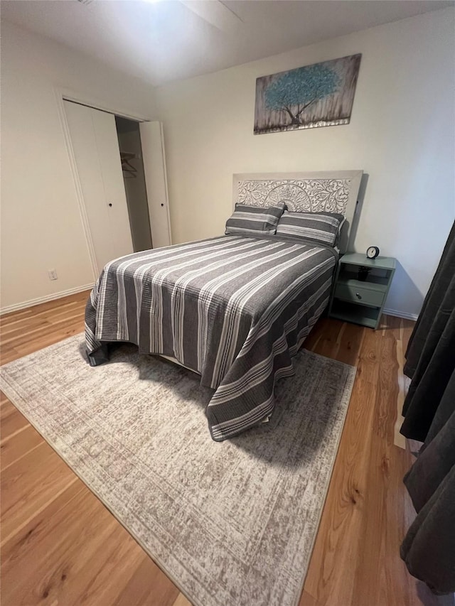 bedroom featuring a closet, wood finished floors, and baseboards