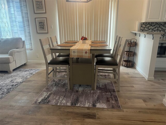 dining room featuring light wood-style flooring and baseboards