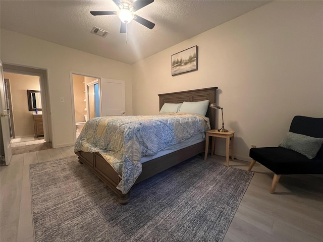 bedroom with light wood-style flooring, visible vents, and a textured ceiling
