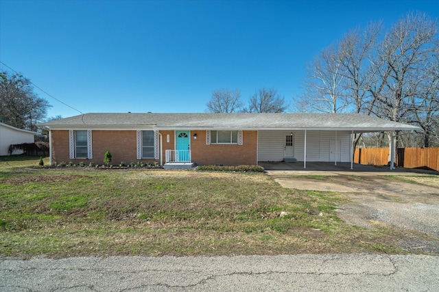 ranch-style home featuring dirt driveway, brick siding, a front yard, and fence