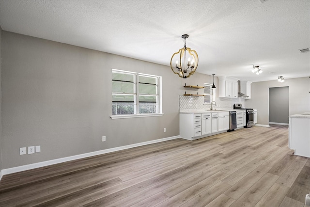 kitchen featuring white cabinets, a sink, stainless steel appliances, light countertops, and backsplash