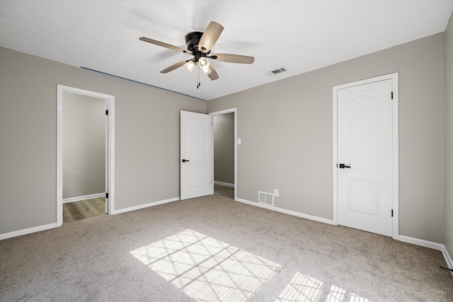 unfurnished bedroom with carpet, visible vents, and baseboards