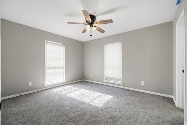 empty room with baseboards, ceiling fan, carpet, and a healthy amount of sunlight