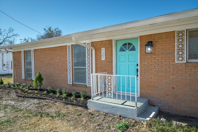 doorway to property featuring brick siding