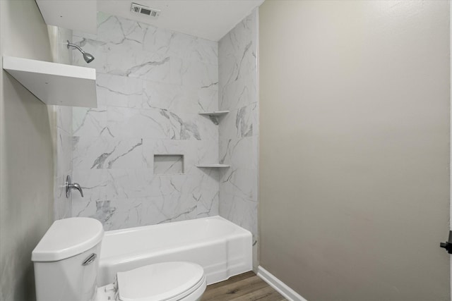 bathroom with shower / bath combination, baseboards, visible vents, toilet, and wood finished floors