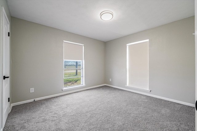 spare room featuring carpet and baseboards