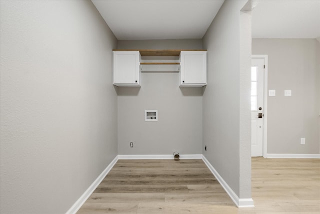 clothes washing area featuring hookup for a washing machine, cabinet space, baseboards, and light wood-style floors