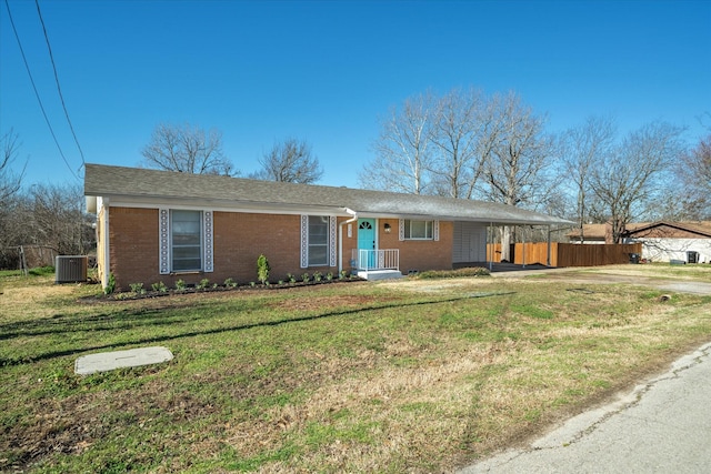 ranch-style home featuring central AC unit, brick siding, fence, a carport, and a front lawn