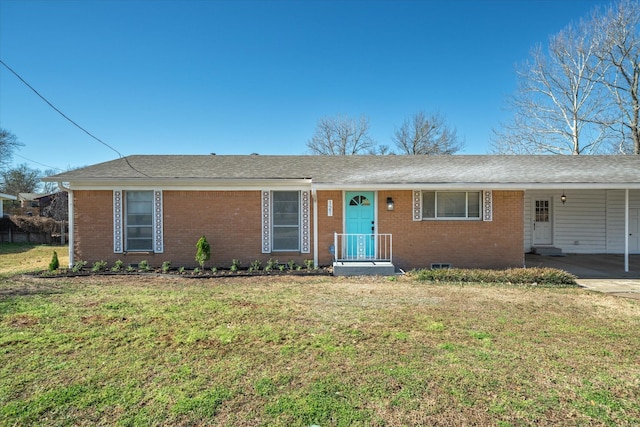 ranch-style home with brick siding, a shingled roof, an attached carport, and a front yard