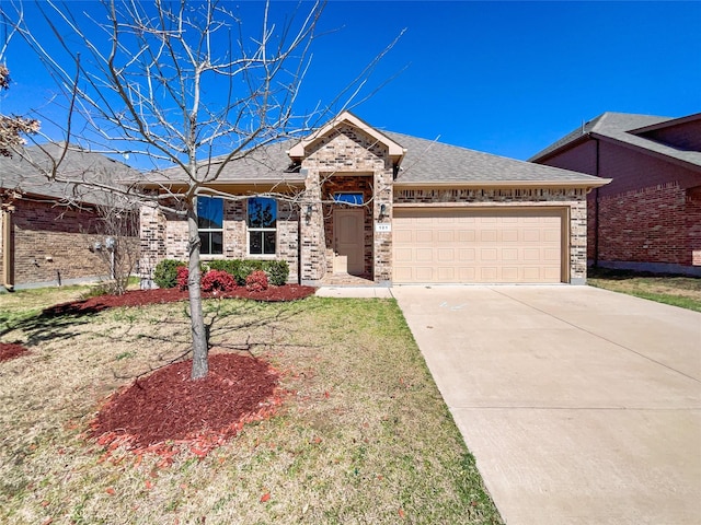 ranch-style home featuring brick siding, roof with shingles, an attached garage, a front yard, and driveway