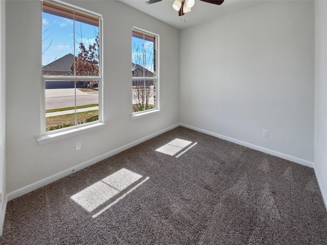 carpeted empty room featuring ceiling fan and baseboards