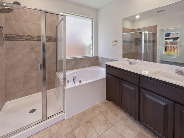 full bathroom with a wealth of natural light, a sink, a bath, and a shower stall