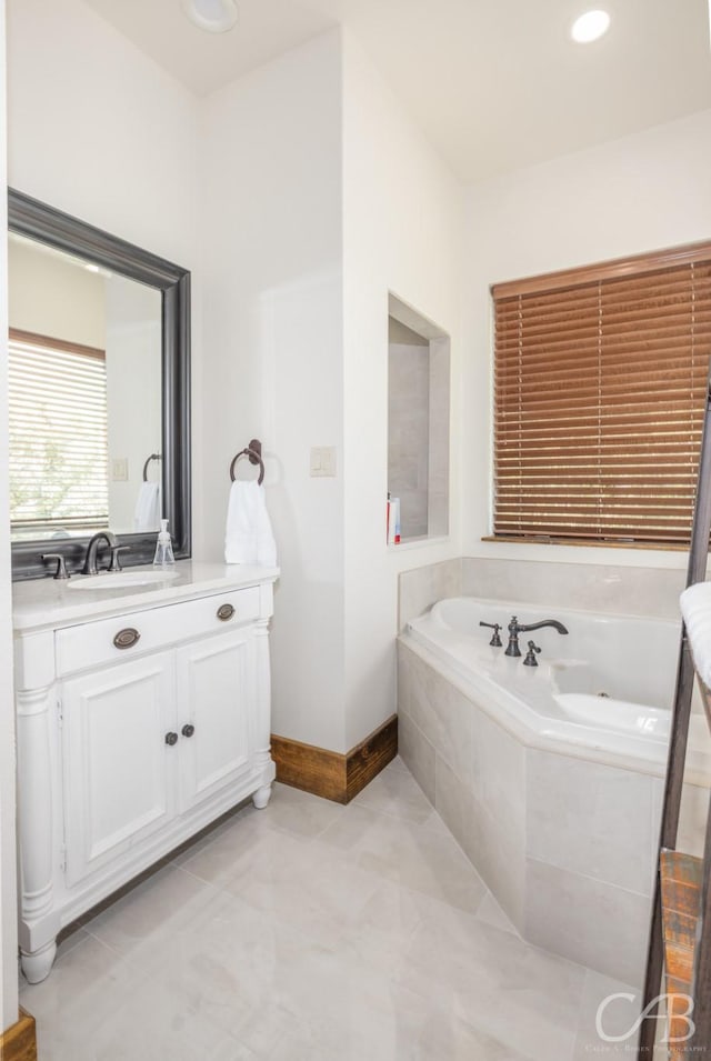 full bath featuring tile patterned flooring, recessed lighting, vanity, baseboards, and a jetted tub