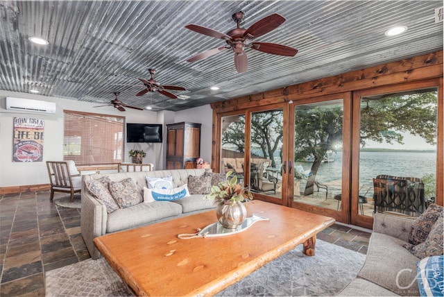 living room with recessed lighting, an AC wall unit, plenty of natural light, and stone tile floors