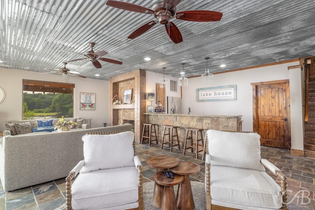 living area with recessed lighting, indoor wet bar, and stone tile floors