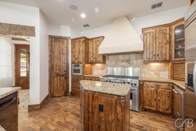 2927 Colonels Row, Possum Kingdom Lake, TX 76449 - kitchen with premium range hood, dark wood-type flooring, stainless steel appliances, and visible vents
