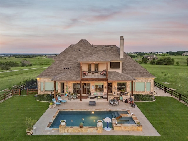 rear view of house with a patio, a yard, an outdoor hangout area, a balcony, and a fenced backyard