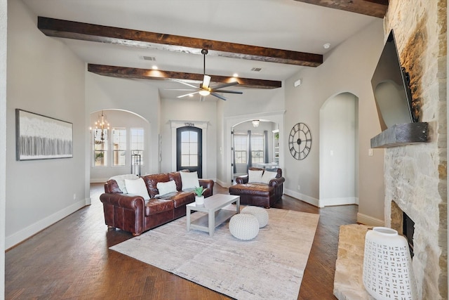 living room with a healthy amount of sunlight, a fireplace, visible vents, and arched walkways