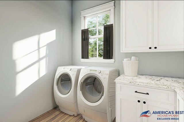 laundry room featuring cabinet space, washing machine and dryer, and light wood-style flooring