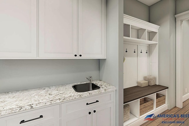 mudroom with light wood-style floors and a sink