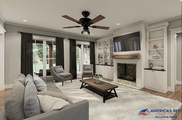 living area with ornamental molding, a fireplace, wood finished floors, and baseboards