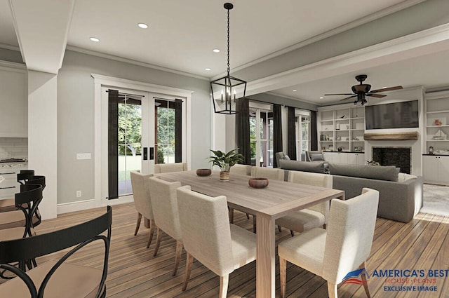 dining room with a wealth of natural light, a fireplace, crown molding, and wood finished floors