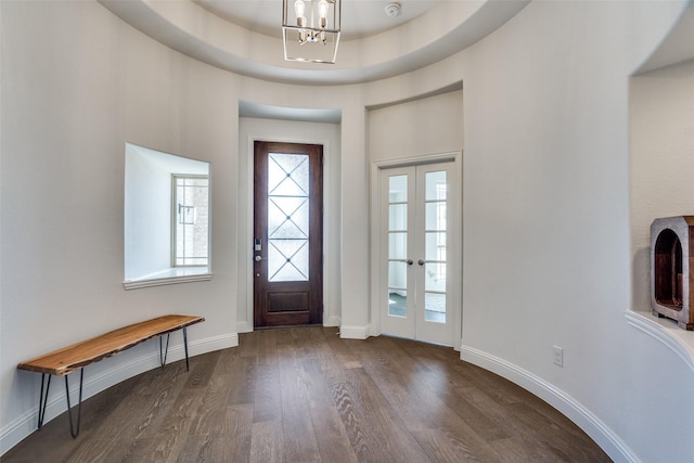 entryway with a notable chandelier, a tray ceiling, french doors, baseboards, and dark wood-style flooring