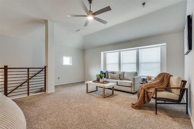 carpeted living area with baseboards, lofted ceiling, and a ceiling fan