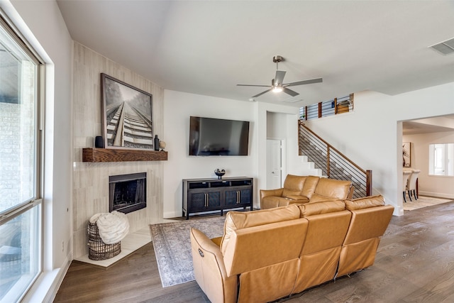 living room with stairs, wood finished floors, visible vents, and a fireplace