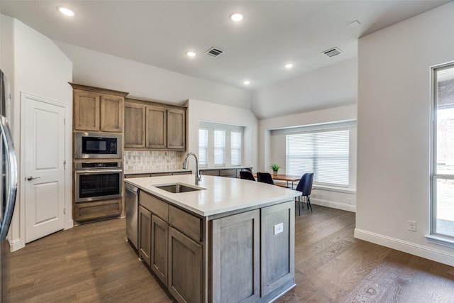 kitchen featuring a sink, vaulted ceiling, visible vents, and stainless steel appliances