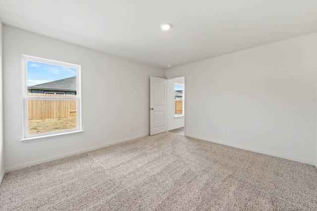 empty room with baseboards and carpet flooring