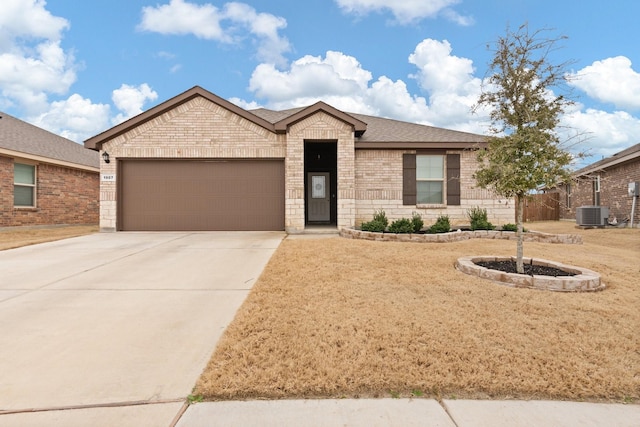 ranch-style home with a garage, brick siding, a shingled roof, concrete driveway, and a front yard