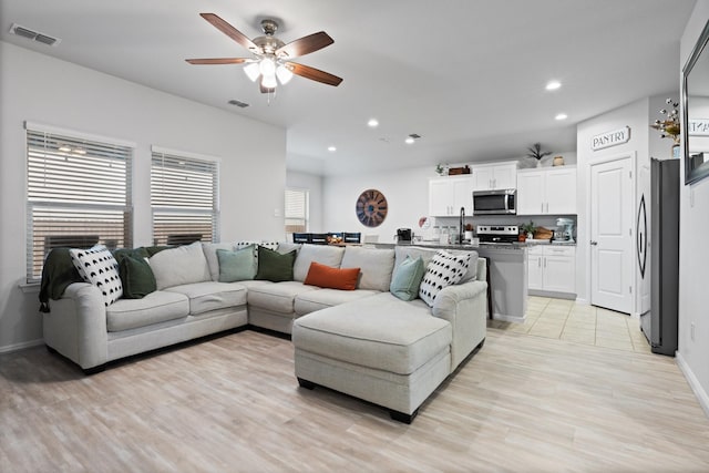 living area with recessed lighting, visible vents, and light wood-style flooring