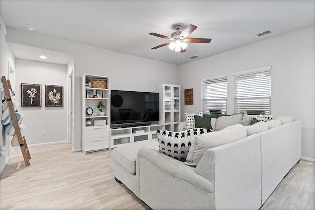 living area featuring visible vents, ceiling fan, and light wood finished floors