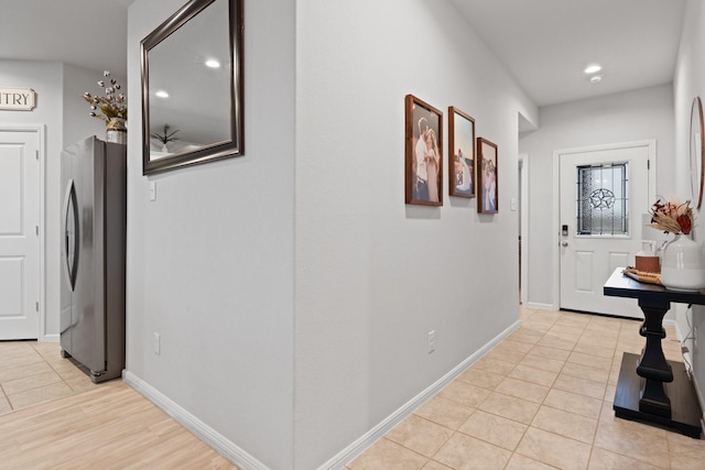 hallway with recessed lighting, baseboards, and light tile patterned floors