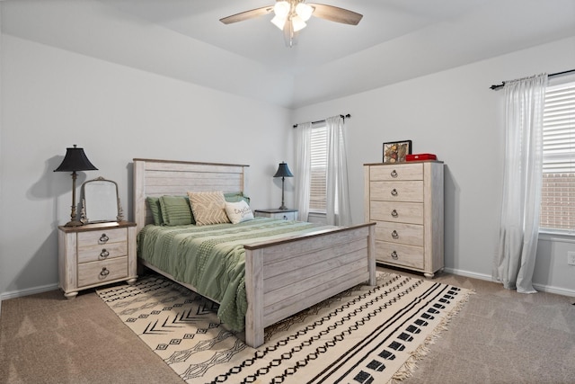 bedroom featuring light carpet, multiple windows, and baseboards