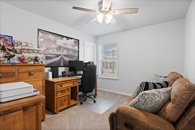 office area featuring light carpet, baseboards, and a ceiling fan