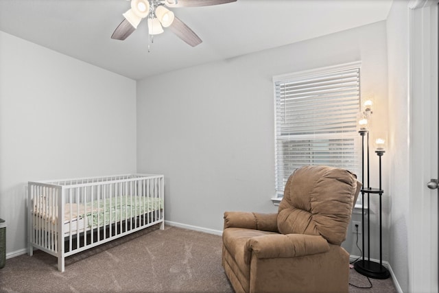 bedroom featuring carpet floors, baseboards, a ceiling fan, and a crib