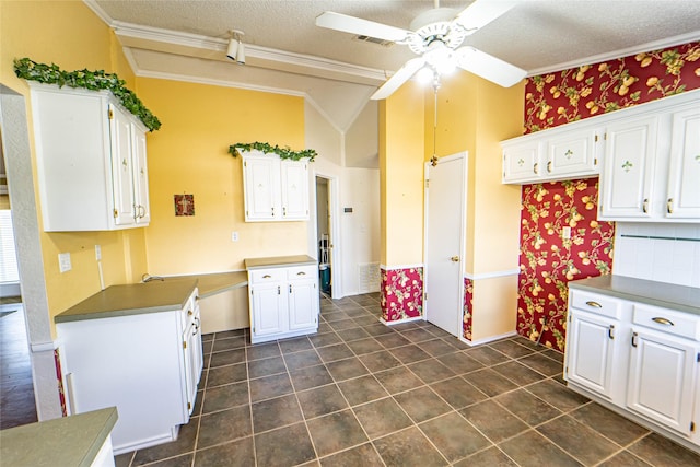 kitchen featuring a ceiling fan, visible vents, white cabinets, and crown molding