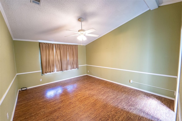 spare room featuring ceiling fan, wood finished floors, visible vents, vaulted ceiling, and crown molding