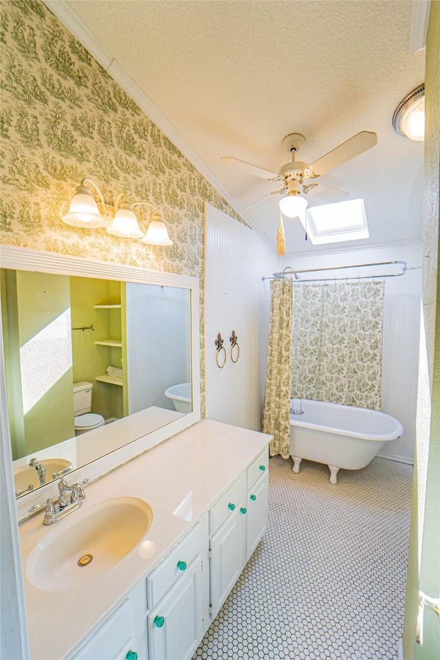 full bathroom featuring a textured ceiling, vanity, a freestanding bath, wallpapered walls, and crown molding